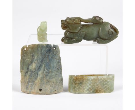 Group of four Chinese carved jade pieces including one sleeping figure, a dog, and two carved plaques with symmetrical design
