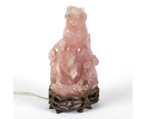 Carved rose quartz lamp in the form of a lidded vase, decorated with pierced and carved birds and branches. On a wooden stand