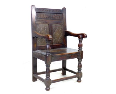 A 17th century and later oak Wainscot armchair, the solid three panel back carved with geometric patterns, shaped arms on tur