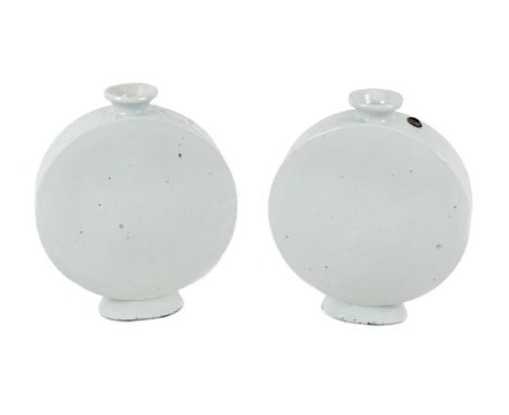 A pair of Chinese porcelain moon flasks, early to mid 20th century, decorated with a white glaze, each retaining a wax 'Jian 