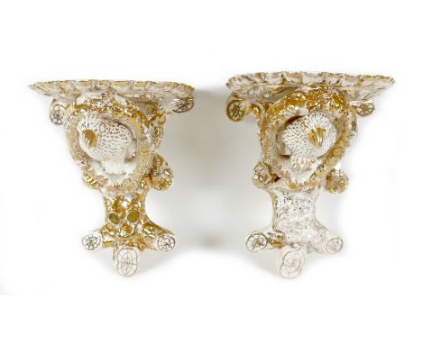 A pair of Staffordshire pottery creamware wall brackets, late 19th century, each modelled with a bird surrounded by a wreath 
