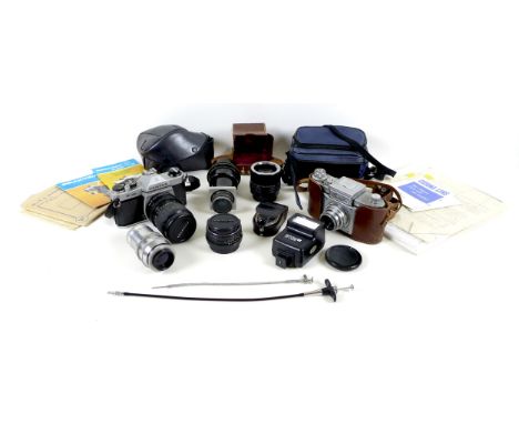 A small group of cameras and equipment, including a Praktiflex camera, an Asahi Pentax K1000 camera, four lenses, a light met
