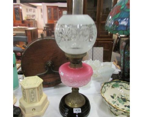 An oil lamp with pink glass a/f font and etched shade