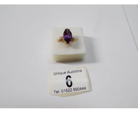An amethyst and diamond yellow metal ring