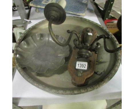 A large metal tray, a pewter dish and a wall light
