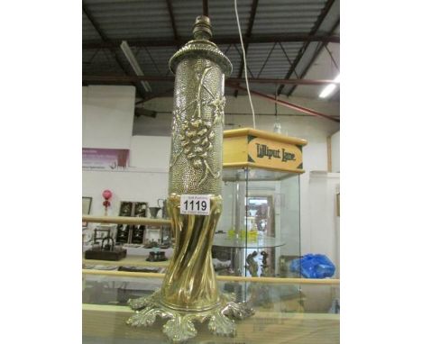 A brass trench art shell case table lamp decorated in relief with grapes, leaves and a blank shield