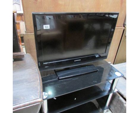 A Samsung flat screen TV on black glass stand