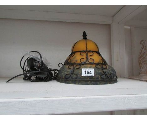 A ceiling light with yellow/blue mottled glass shade