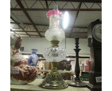 An oil lamp with shade and with maker's mark to brass base