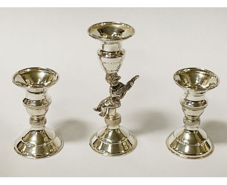 SHORT CHERUB CANDLESTICK WITH AN ACCOMPANYING PAIR OF SHORT CANDLESTICKS