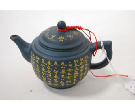 A small Yixing teapot and cover, having incised calligraphy type decoration, with impressed seal mark verso, h.9cm