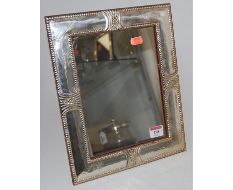 A large modern white metal clad easel mirror, the rectangular plate within a pressed white metal surround within beaded borde