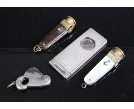 A mid-20th century silver guillotine cigar cutter having engine turned decoration, together with three other pocket cigar cut