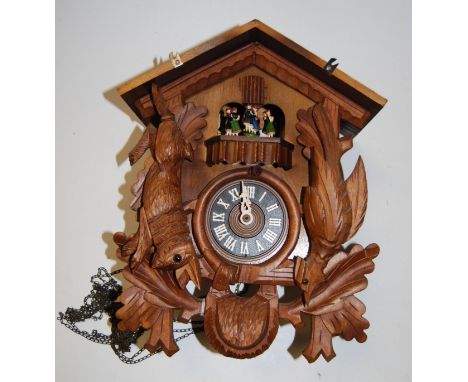 A modern carved softwood cuckoo clock with weights