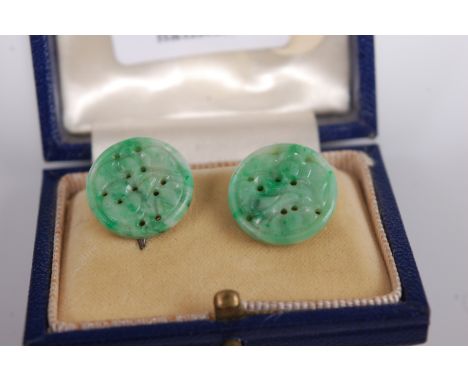 A pair of carved celadon jade ear clips each of circular form with green striations, dia. 16mm