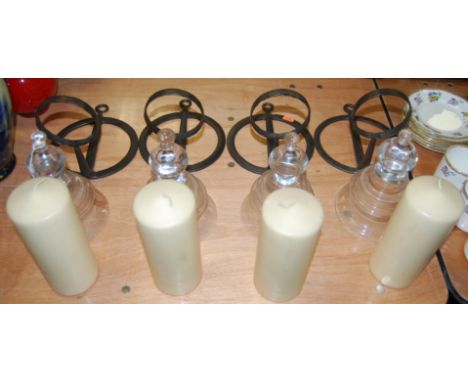 A set of four wrought iron wall light fittings, each having a knopped glass bowl and candle
