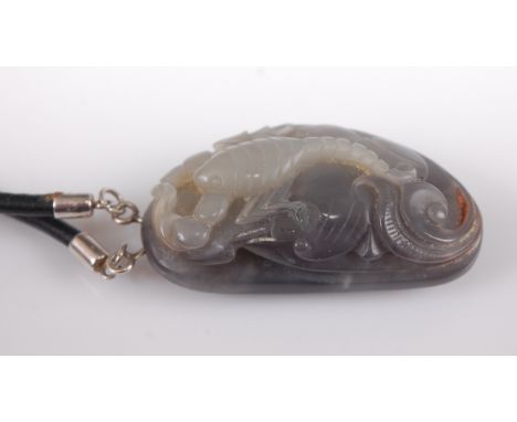 A Chinese carved jade pendant having purple striations 5cm, and on leather neckchain