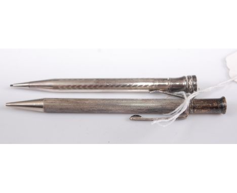 An engine turned silver propelling pencil; together with a silver plated example (2)
