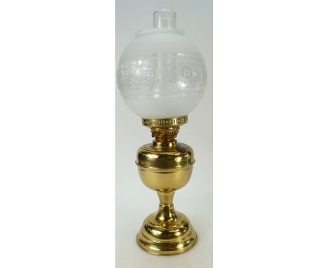 A brass oil lamp base with glass chimney and glass shade. 