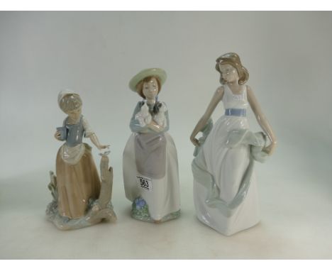 A collection of Nao porcelain figures including Girl holding puppies,Girl with butterfly and girl holding dress, tallest heig