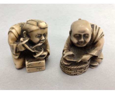 Two Japanese netsuke, both seated and dressed in robes, one eating noodles, approx 4cm in height 