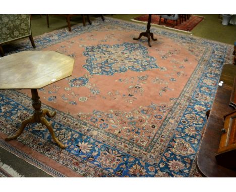 Indo-Persian carpet, North India, the pale peach field sparcely decorated with vines around a pole medallion framed by spandr