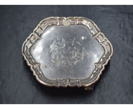 An Edwardian silver visiting card/alms tray, of hexagonal form having a rounded lobed rim and a central engraved coat of arms