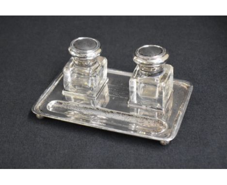 A George V silver inkwell stand, of rectangular form having thread rim, having personal engraving to the centre, with two squ