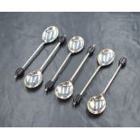 A cased set of six George V silver coffee bean spoons, having black coffee beans to the terminals,