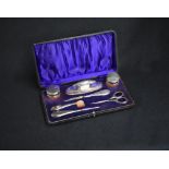 A cased George V silver mounted and capped manicure set, having thread decoration, marks for