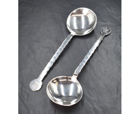A cased pair of George V silver serving spoons, having a Chippendale style edge with a pelican heraldic crest to the terminal