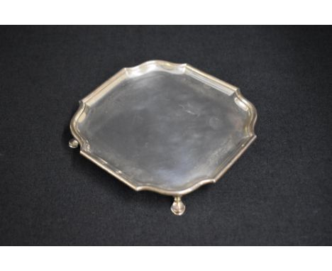 A George VI silver salver, of square form having a Chippendale style rim, raised on four hoof style legs, marks for London 19