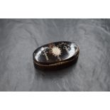 A 20th century white metal inlaid tortoiseshell trinket box, of hinged oval form having a vacant