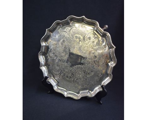 An Elkington &amp; Co silver plated salver, of circular form having a Chippendale style rim with central decorative engraving