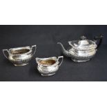 A Victorian silver three piece tea set, comprising a tea pot, sugar and cream, each of oval half-