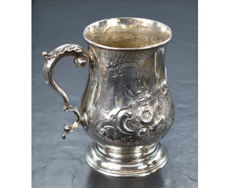 A Victorian silver tankard, of traditional bulbous form having a slightly flared rim, scroll handle, embossed floral decorati