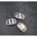 Three Elizabeth II silver decanter labels, of rectangular form having scroll and shell borders for