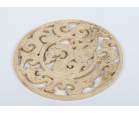 A Chinese calcified jade pierced roundel medallion decorated with stylized mythical beasts, 13.25cm. Condition Report. To be 