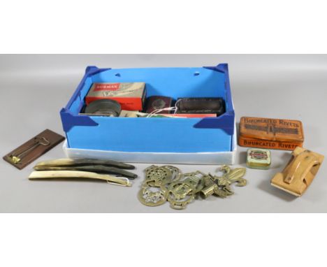 A box of collectables including printing equipment, vintage advertising tins and horse brasses etc.