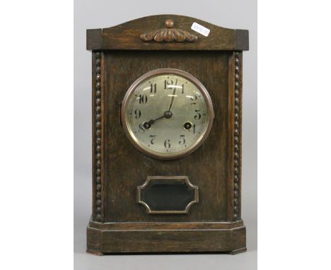 An oak cased eight day mantel clock chiming on a coiled gong.
