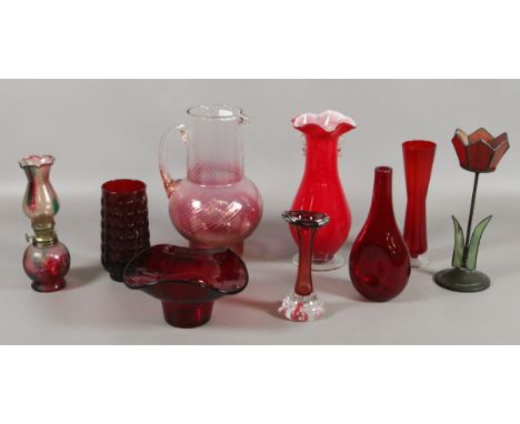 A collection of glassware to include ruby vases and bowls, ornamental oil lamp and a cranberry tinted lemonade jug, etc.