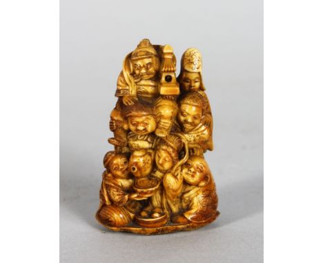 A GOOD JAPANESE CARVED IVORY NETSUKE, depicting a tea making ceremony. 2.25ins high.