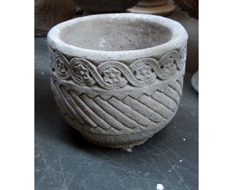 A circular stone planter decorated with flowerheads around the rim, 36 x 28cm