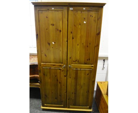 A contemporary pine wardrobe, two cross banded fielded panelled doors, bracket feet, 99 cm x 190.5 cm x 63.5 cm