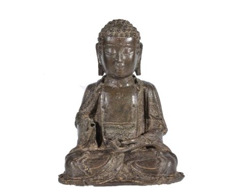 A Chinese bronze seated figure of Buddha, 17th century, cast with legs neatly crossed in dhyanasana, the hands in front of th