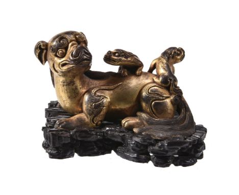 A Chinese gilt-bronze 'lion' scroll weight, cast as a recumbent lion with its two young riding on its back, the mane is detai
