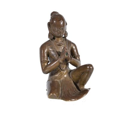A Nepalese bronze portrait of a royal donor from a shrine, Nepal, circa 18th century, the female figure sitting with one knee