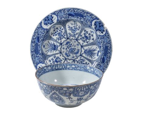 A large Chinese blue and white dish, Kangxi, painted with radiating petal shaped panels of flowers and the border with flower