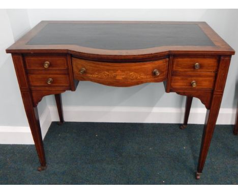 An Edwardian rosewood and marquetry writing table, the bow fronted top with a black leather insert above an arrangement of fi