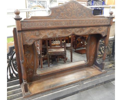 An early 20thC carved oak over mantel mirror, with turned supports and a shelf, 111cm wide.